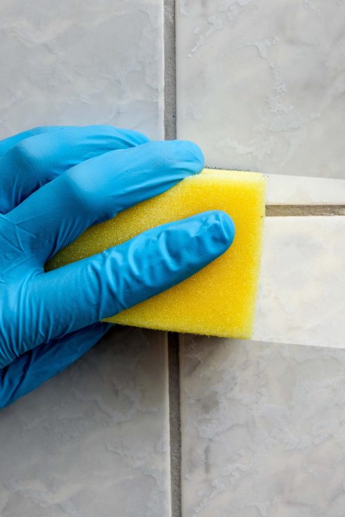 Cleaning sponge held in hand while cleaning bathroom